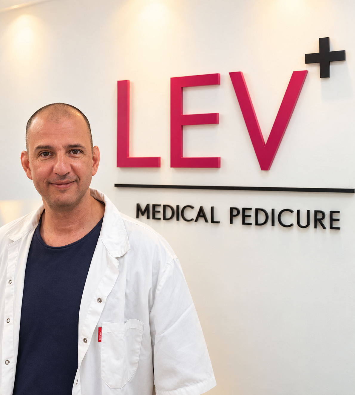 בועז במרפאה, על רקע השלט LEV Medical Pedicure
